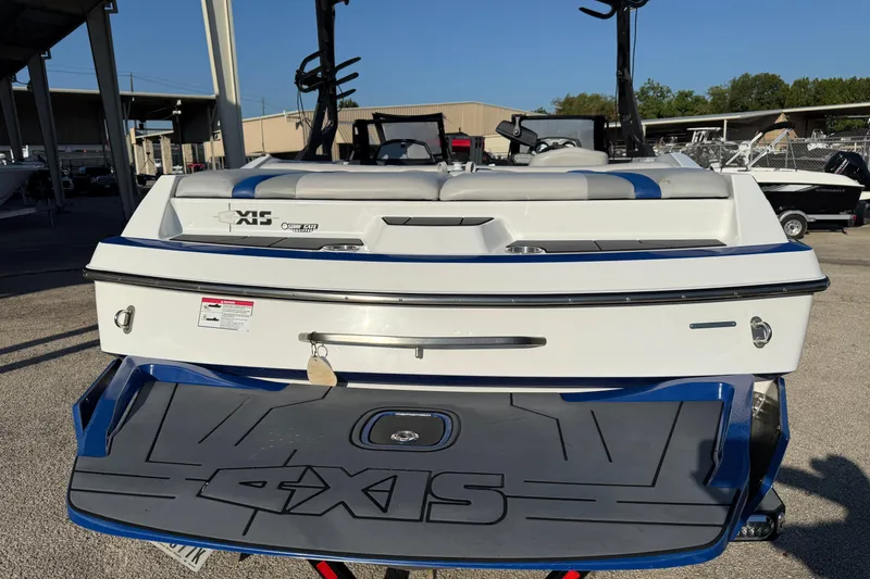 Slide: The Image of 2018 Axis A20 boat rear view with swim platform in a marina setting. - 4