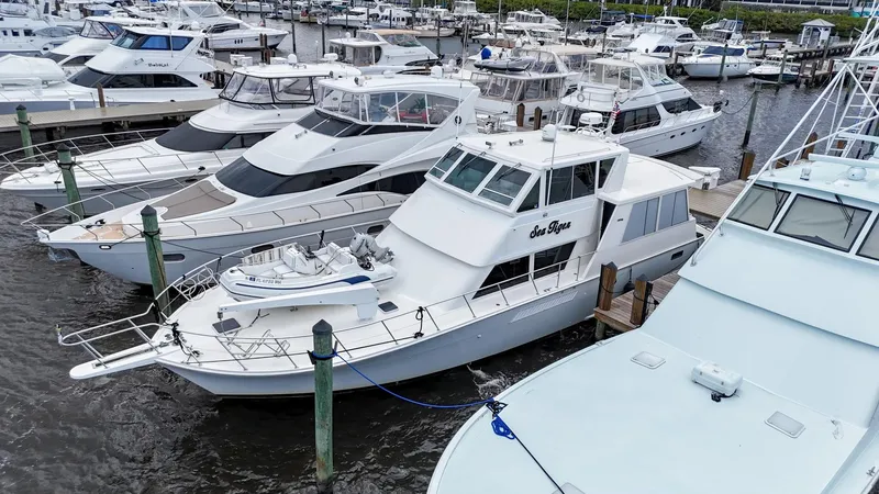 The Image of 1996 Viking 60 Cockpit Sport Yacht docked among other luxury boats at a marina. - 1