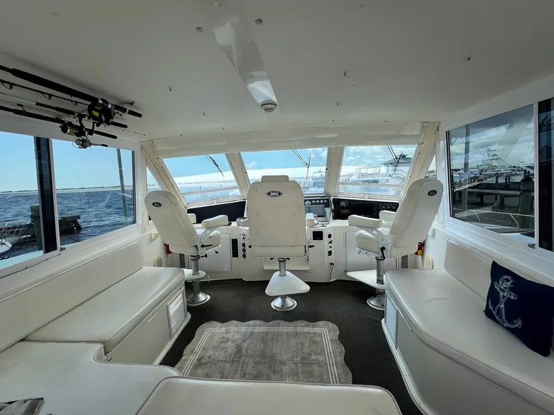 Slide: The Image of Interior of 1996 Viking 60 Cockpit Sport Yacht with white seating and ocean view. - 14