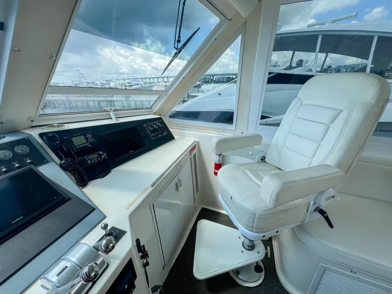 Slide: The Image of Helm of 1996 Viking 60 Cockpit Sport Yacht with white captain's chair and navigation equipment. - 15