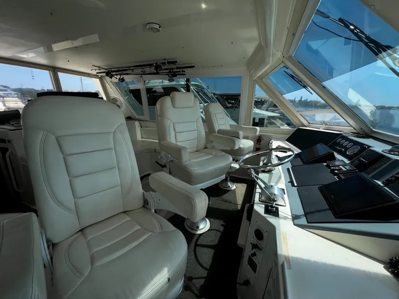Slide: The Image of Interior of 1996 Viking 60 Cockpit Sport Yacht with luxurious white seating and modern controls. - 17