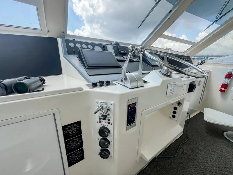 Slide: The Image of 1996 Viking 60 Cockpit Sport Yacht helm with steering wheel and control panels. - 21