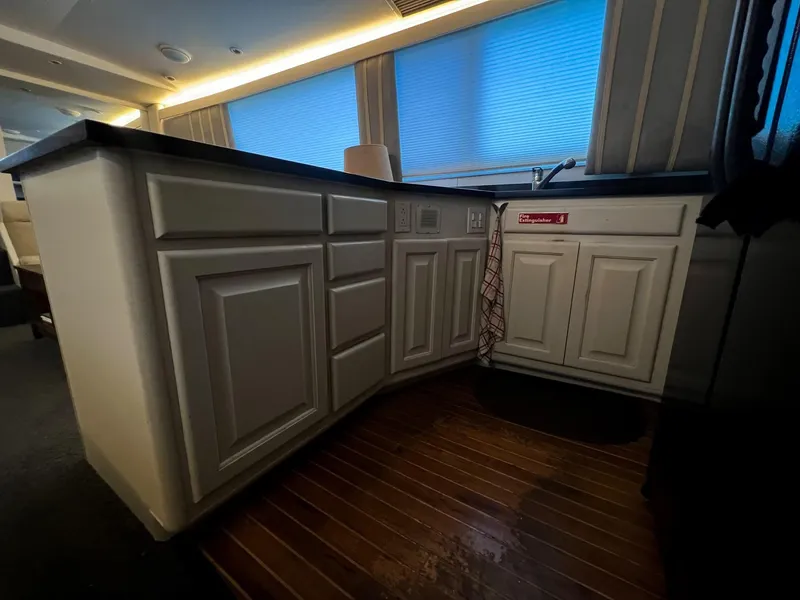 Slide: The Image of Interior kitchen of 1996 Viking 60 Cockpit Sport Yacht with wooden flooring and cabinetry. - 28