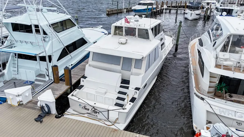 Slide: The Image of 1996 Viking 60 Cockpit Sport Yacht docked between boats at a marina. - 3