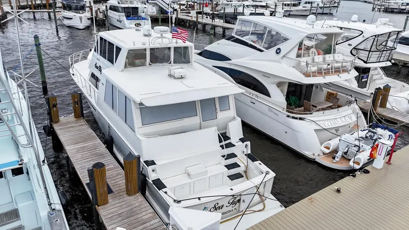 Slide: The Image of 1996 Viking 60 Cockpit Sport Yacht docked at marina, surrounded by other boats. - 4