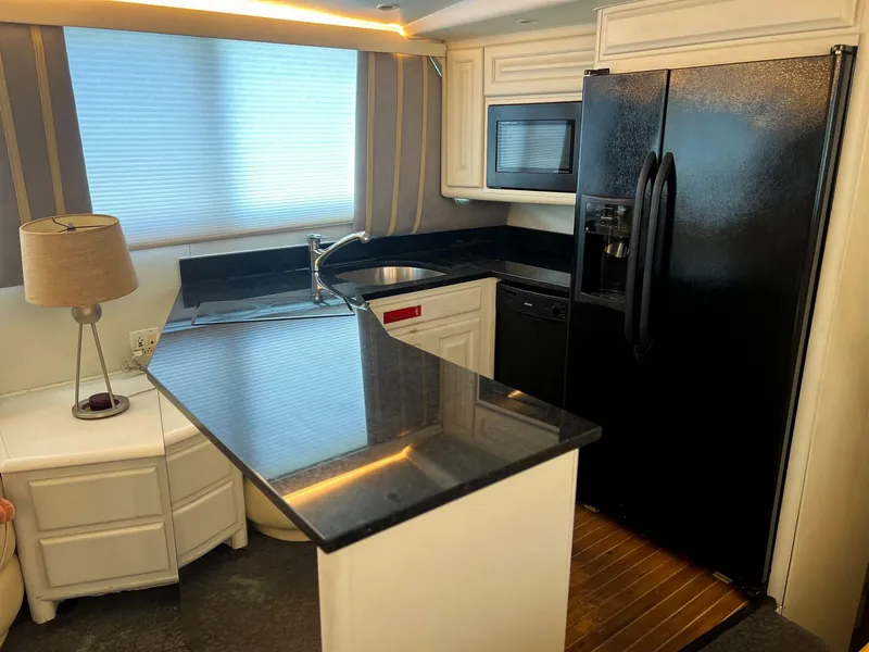 Slide: The Image of Kitchen area of a 1996 Viking 60 Cockpit Sport Yacht with modern appliances. - 43