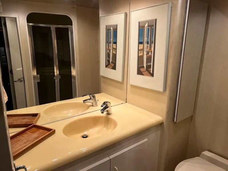 Slide: The Image of Bathroom interior of 1996 Viking 60 Cockpit Sport Yacht with dual sinks and framed artwork. - 46