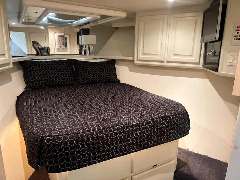 Slide: The Image of 1996 Viking 60 Cockpit Sport Yacht bedroom with black patterned bedding and white cabinetry. - 47