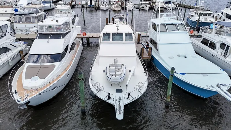 Slide: The Image of Three yachts docked at a marina, featuring a 1996 Viking 60 Cockpit Sport Yacht. - 7