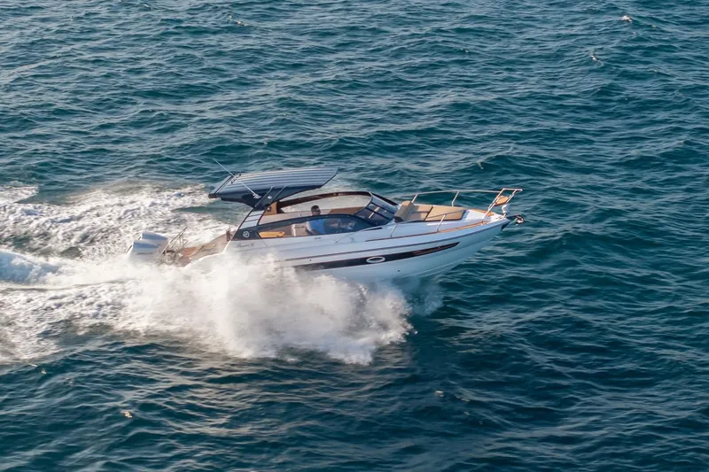 Slide: The Image of 2026 Hanover 305 boat cruising on open sea, creating waves. - 14