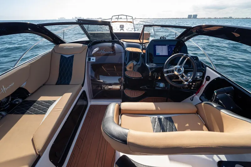 Slide: The Image of Luxurious 2026 Hanover 305 boat interior with plush seating and modern dashboard on open water. - 16