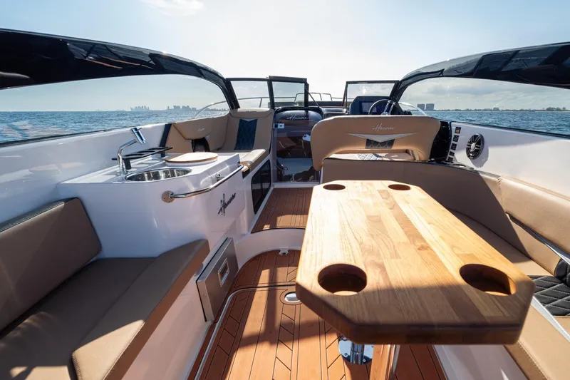 Slide: The Image of Luxurious 2026 Hanover 305 boat interior with wooden table, seating, and ocean view. - 20