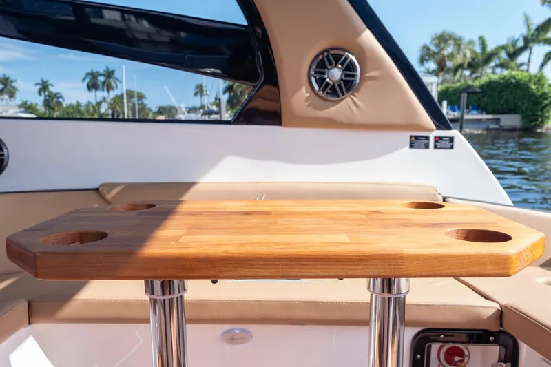 Slide: The Image of Luxury Hanover 305 boat interior with wooden table, cup holders, and scenic water view, 2026 model. - 43