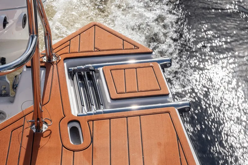 Slide: The Image of 2026 Hanover 305 boat deck with wooden finish and chrome details on water. - 44