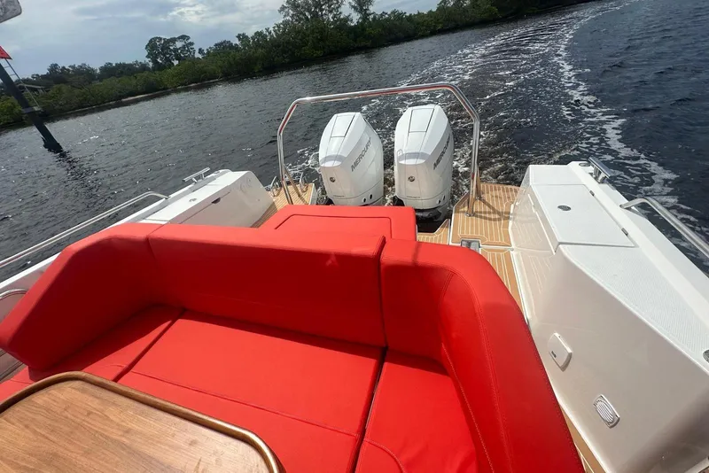 Slide: The Image of 2025 Nimbus Tender 11 boat with red seating and dual outboard motors on the water. - 10