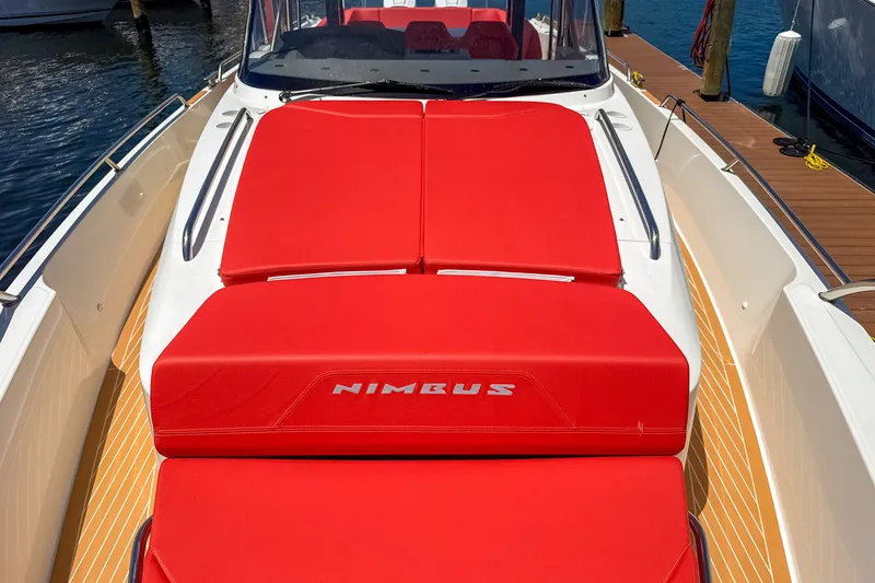 Slide: The Image of 2025 Nimbus Tender 11 boat with vibrant red seating, docked by the water. - 26