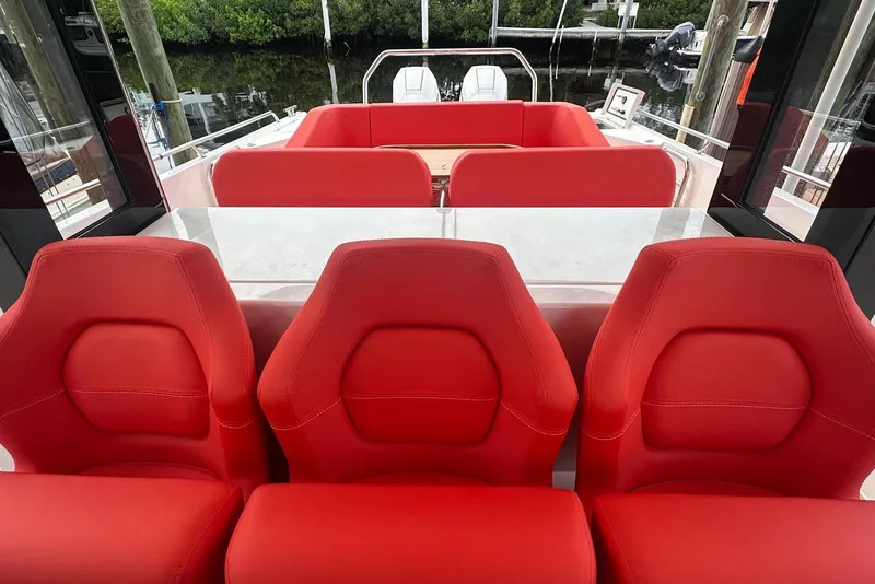 Slide: The Image of Red interior seating on 2025 Nimbus Tender 11 boat, docked near water. - 6