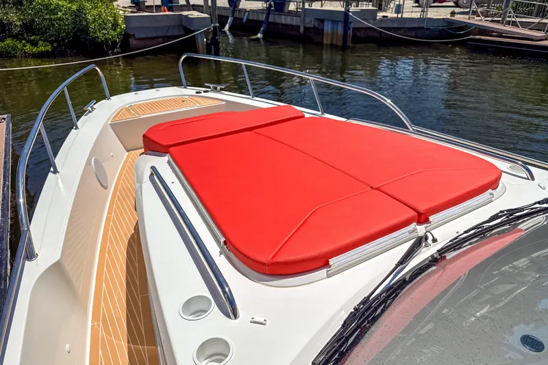 Slide: The Image of 2025 Nimbus Tender 11 boat with red sunbed, docked by the water. - 27