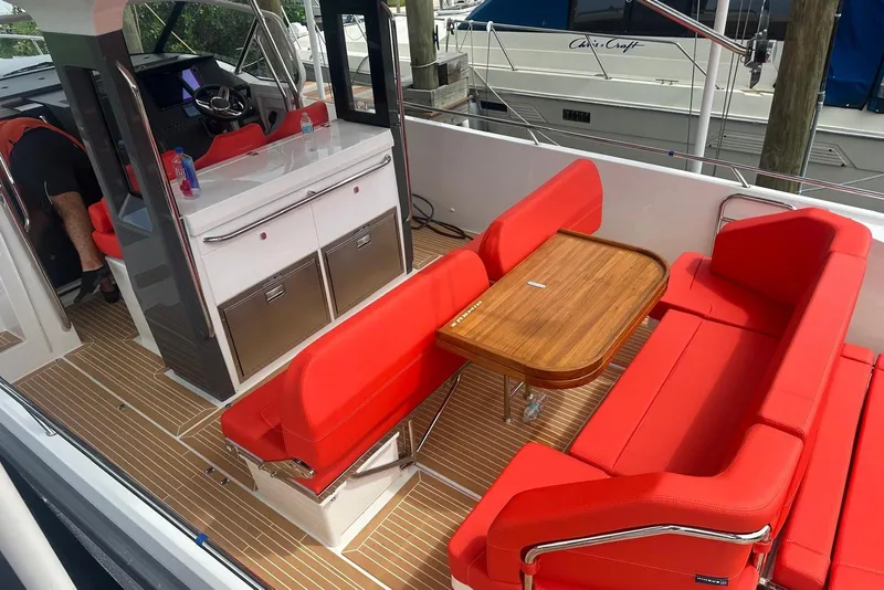 Slide: The Image of Luxurious 2025 Nimbus Tender 11 boat interior with red seating and wooden table. - 7