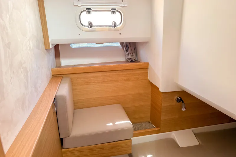 Slide: The Image of Interior of 2025 Nimbus Tender 11, featuring a cozy seating area with wooden accents. - 24
