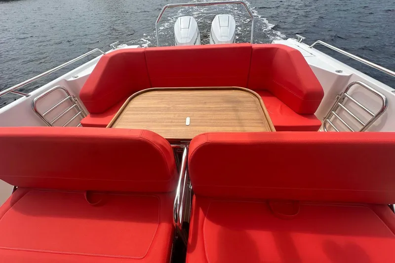 Slide: The Image of Red seating area on 2025 Nimbus Tender 11 boat with wooden table. - 9