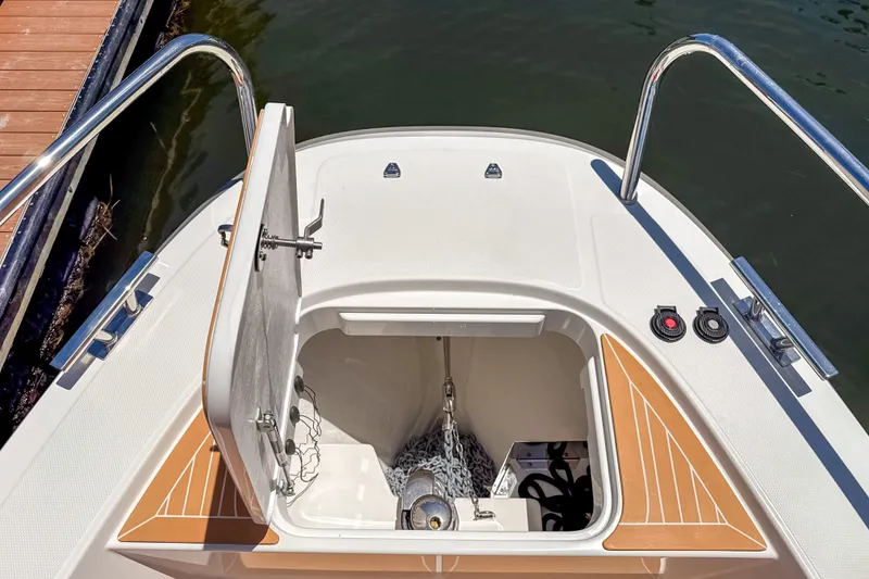 Slide: The Image of Open anchor compartment on 2025 Nimbus Tender 11 boat, dockside view. - 29