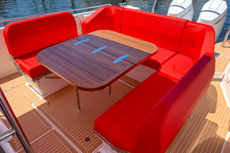 Slide: The Image of Red seating and wooden table on 2025 Nimbus Tender 11 boat deck. - 6