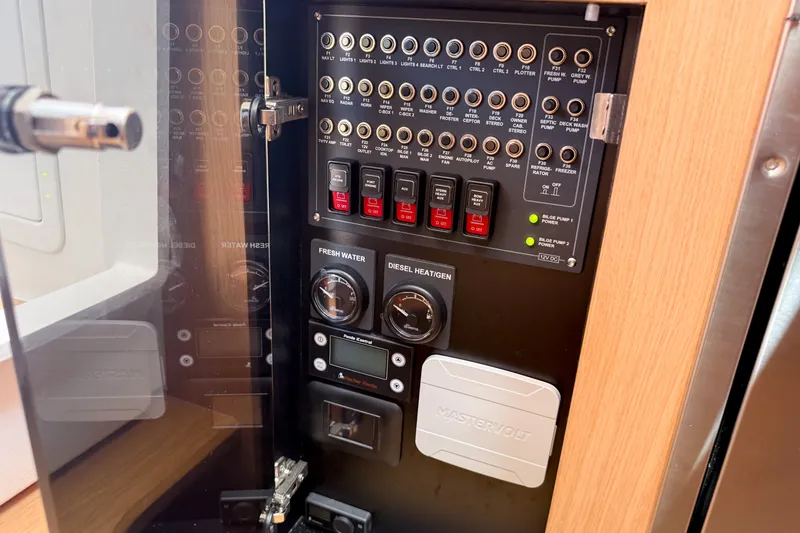 Slide: The Image of Electrical control panel inside 2025 Nimbus Tender 11 boat, featuring switches and gauges. - 22