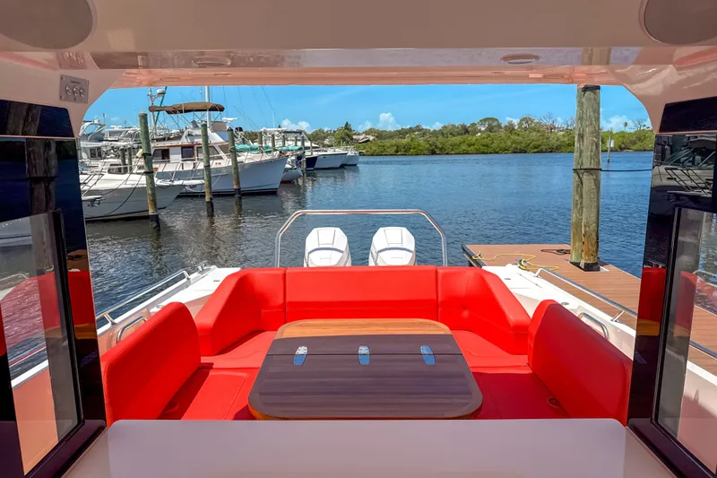 Slide: The Image of Luxurious 2025 Nimbus Tender 11 with vibrant red seating, docked by serene waters. - 7