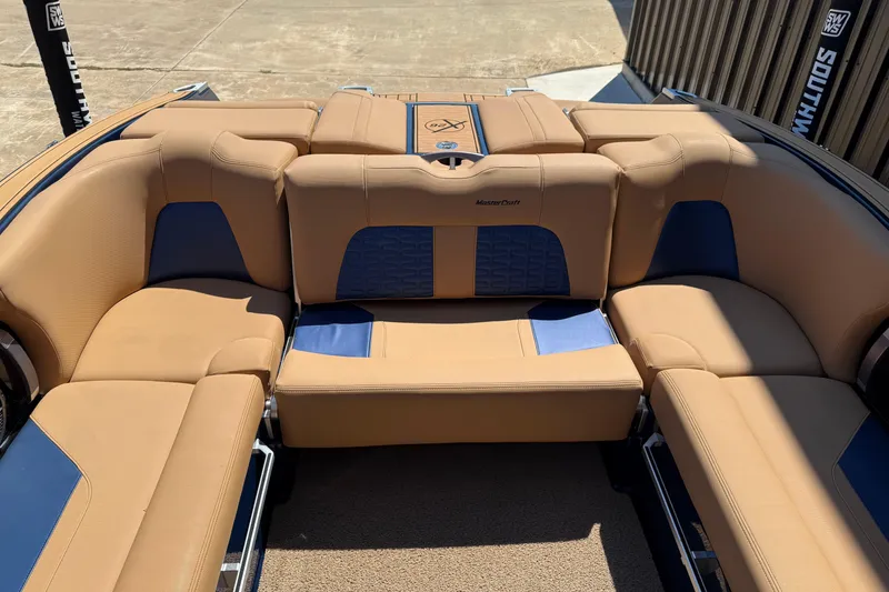 Slide: The Image of 2019 MasterCraft X26 boat interior with tan and blue seating, showcasing luxury design. - 8