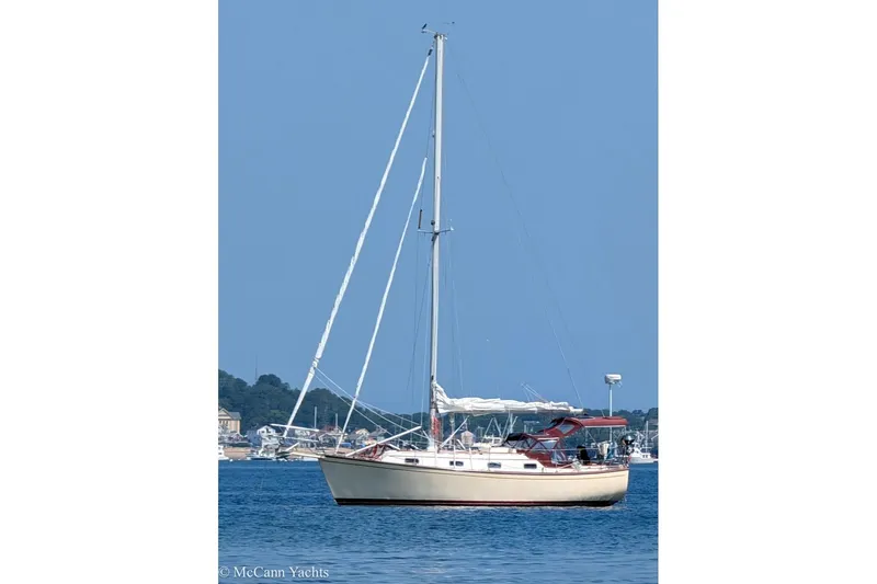 Slide: The Image of 1989 Island Packet 31 sailboat anchored on calm blue water. - 1