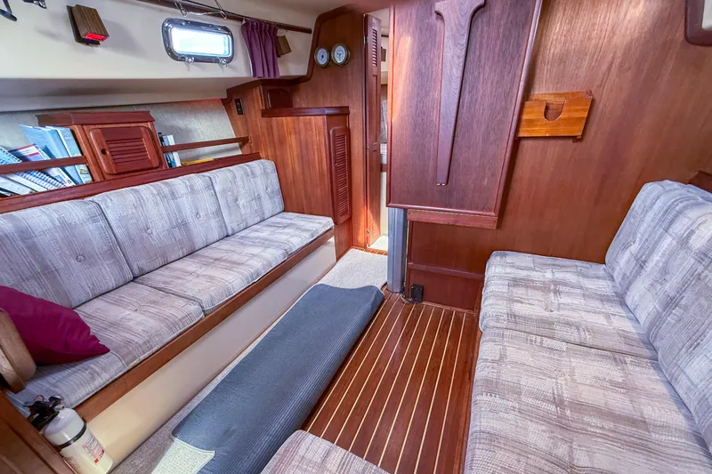 Slide: The Image of Interior of 1989 Island Packet 31 sailboat with cozy seating and wooden finishes. - 14