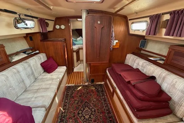 Slide: The Image of Interior of 1989 Island Packet 31 sailboat with cozy seating and wooden finishes. - 15