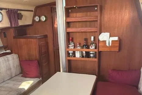 Slide: The Image of 1989 Island Packet 31 yacht interior with wooden cabinetry and cozy seating area. - 16