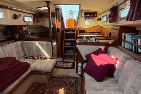 Slide: The Image of Interior of 1989 Island Packet 31 sailboat with cozy seating and nautical decor. - 23