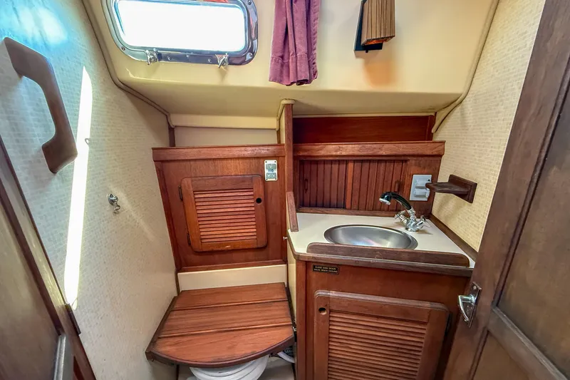 Slide: The Image of 1989 Island Packet 31 yacht bathroom with wooden cabinetry and stainless steel sink. - 26