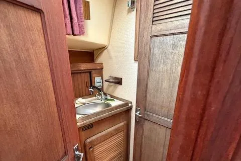 Slide: The Image of 1989 Island Packet 31 yacht interior bathroom with wooden cabinetry and sink. - 29