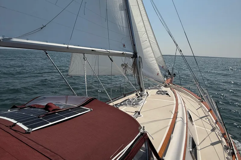 Slide: The Image of 1989 Island Packet 31 sailboat cruising on open water under clear skies. - 3