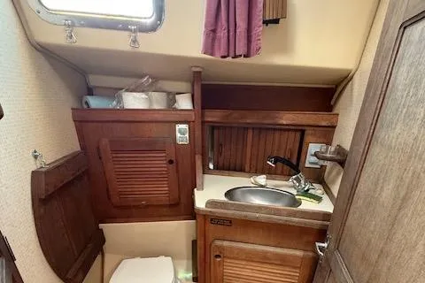 Slide: The Image of 1989 Island Packet 31 sailboat bathroom with wooden cabinetry and compact sink. - 30