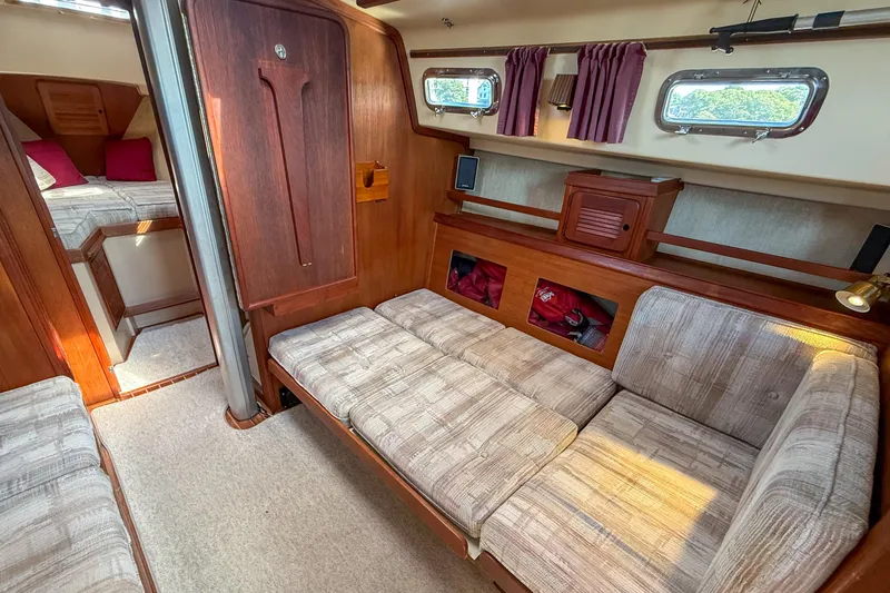 Slide: The Image of 1989 Island Packet 31 yacht interior with cozy seating, wood accents, and natural light. - 31
