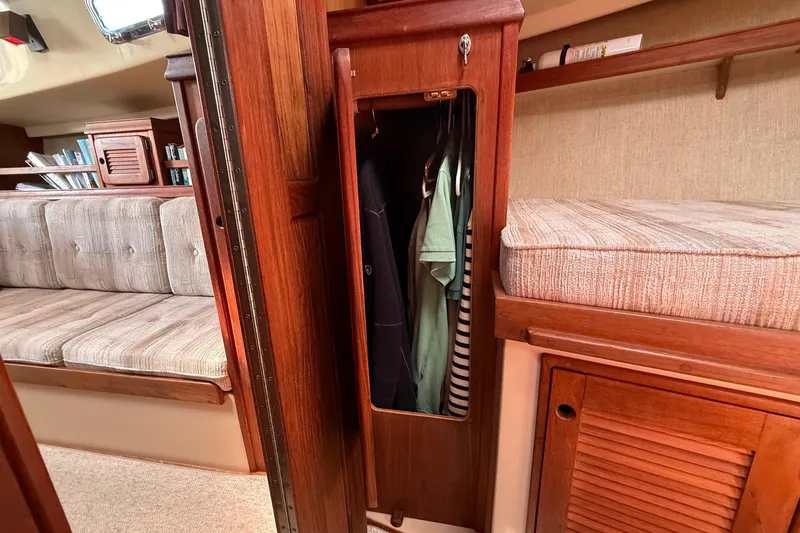 Slide: The Image of Interior of 1989 Island Packet 31 sailboat with wooden cabinetry and cozy seating area. - 37