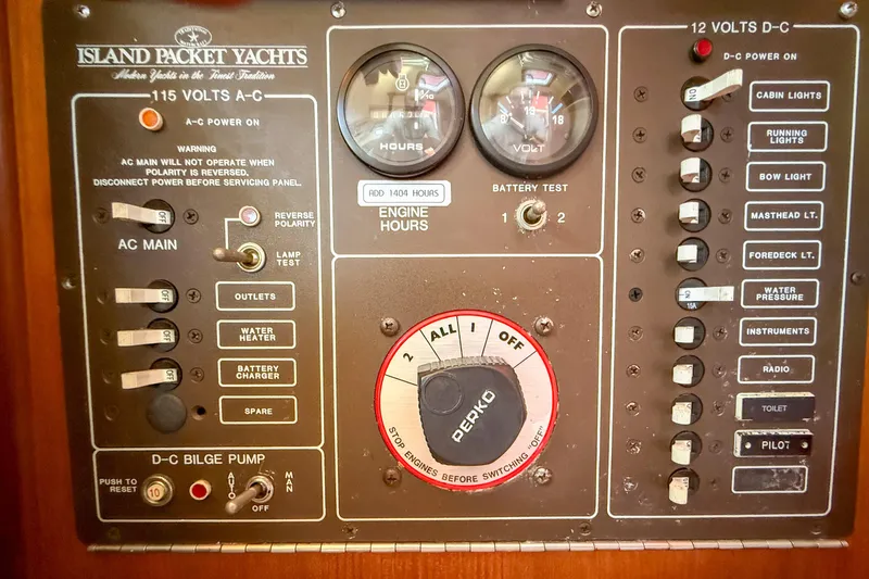Slide: The Image of Control panel of a 1989 Island Packet 31 yacht, featuring various switches and gauges. - 40
