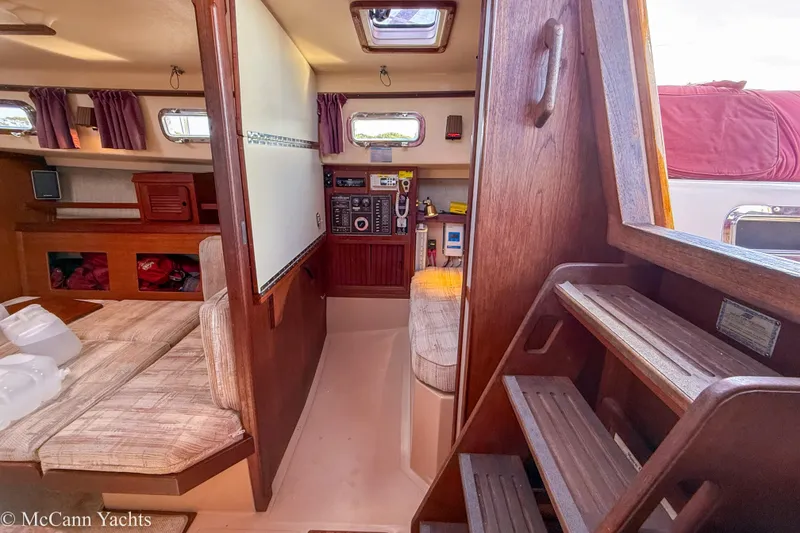 Slide: The Image of Interior of 1989 Island Packet 31 sailboat with wooden finishes and cozy seating area. - 49