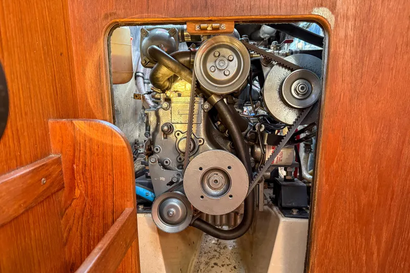Slide: The Image of Engine compartment of a 1989 Island Packet 31 sailboat, showcasing mechanical components. - 57