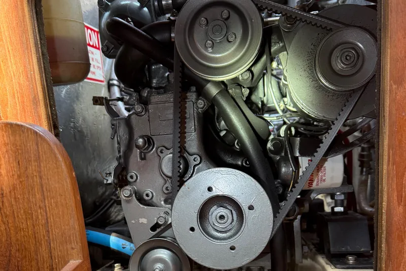 Slide: The Image of Engine compartment of a 1989 Island Packet 31 sailboat, showcasing belts and pulleys. - 58