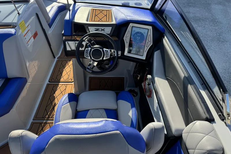 Slide: The Image of 2019 Tigé ZX5 boat interior with blue and gray seating, modern dashboard, and touchscreen controls. - 12
