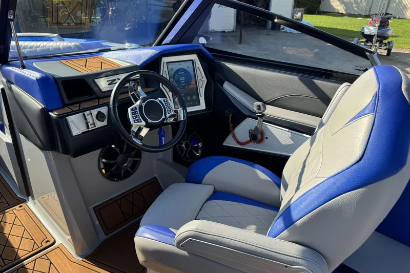 Slide: The Image of 2019 Tigé ZX5 boat interior with blue and gray seating, modern dashboard, and steering wheel. - 6