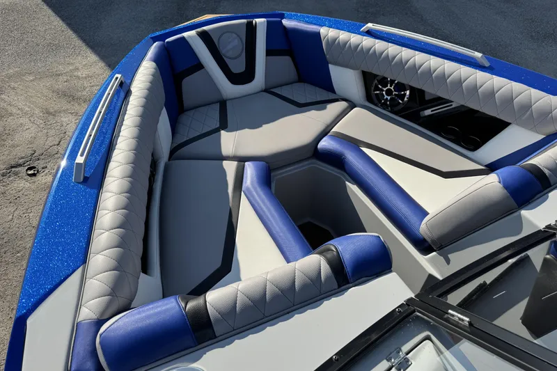 Slide: The Image of 2019 Tigé ZX5 boat interior with blue and gray seating, diamond stitching, and speaker detail. - 8