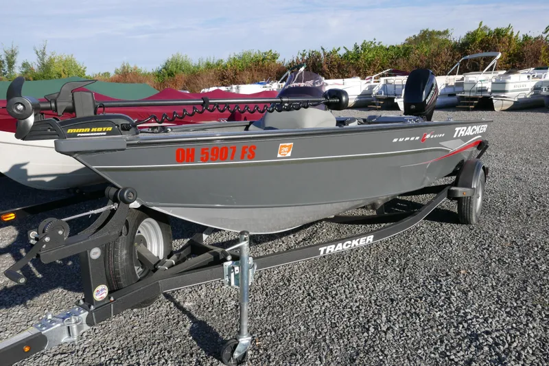Slide: The Image of 2018 Tracker Super Guide V-16 boat on trailer, parked on gravel lot. - 2