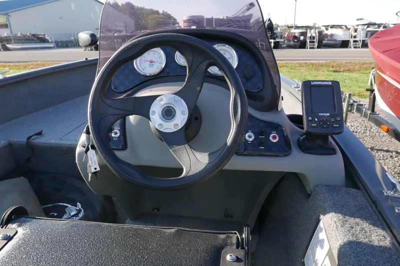 Slide: The Image of 2018 Tracker Super Guide V-16 boat dashboard with steering wheel and Lowrance fish finder. - 8